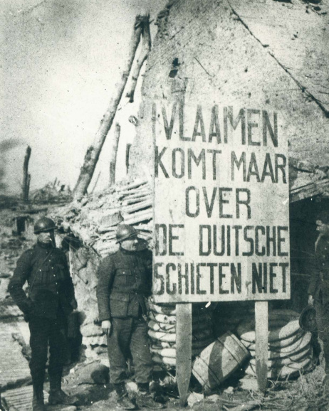 Ook aan het front voerden de Duitsers een Flamenpolitik. In een op het Duitse leger veroverde loopgravenstelling poseren Belgische soldaten bij een bord dat Vlaamse soldaten moest aangemoedigen om over te lopen. (ADVN, VFA3663)