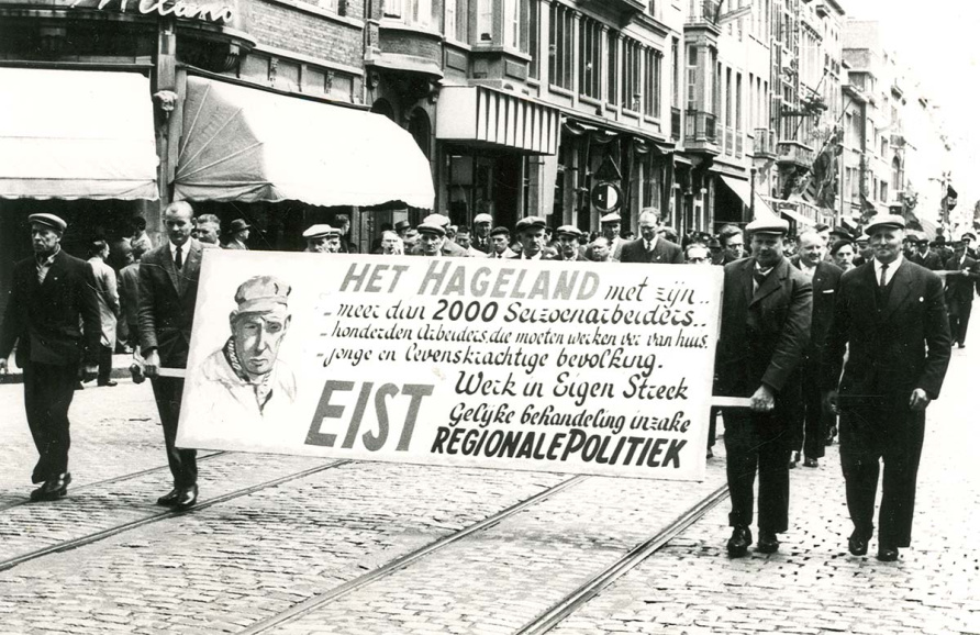 Dat de communautaire tegenstelling een duidelijke economische dimensie kreeg vanaf het einde van de jaren 1950, vertaalt zich bij uitstek in de 'werk in eigen streek'-slogan voor de ontwikkeling van een regionale tewerkstelling (Rerum Novarum-betoging, Leuven, s.d.) (KADOC)